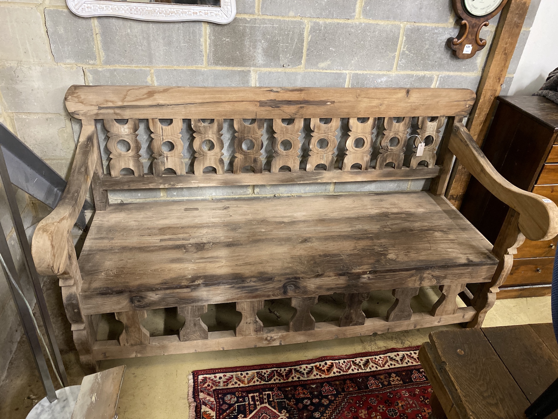 A carved hardwood settle from reclaimed boat timbers, length 191cm, depth 83cm, height 107cm